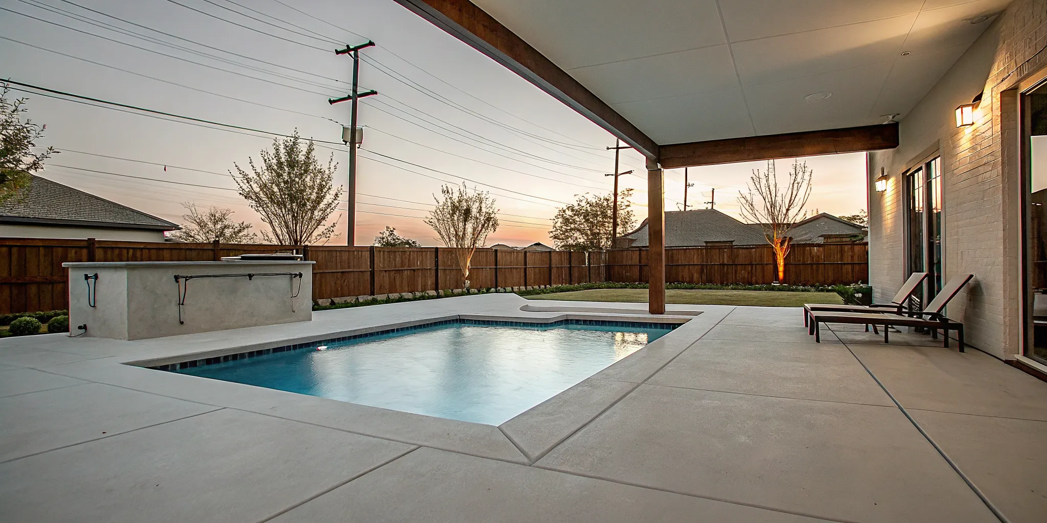 DFW backyard pool with LED pool lights at dusk